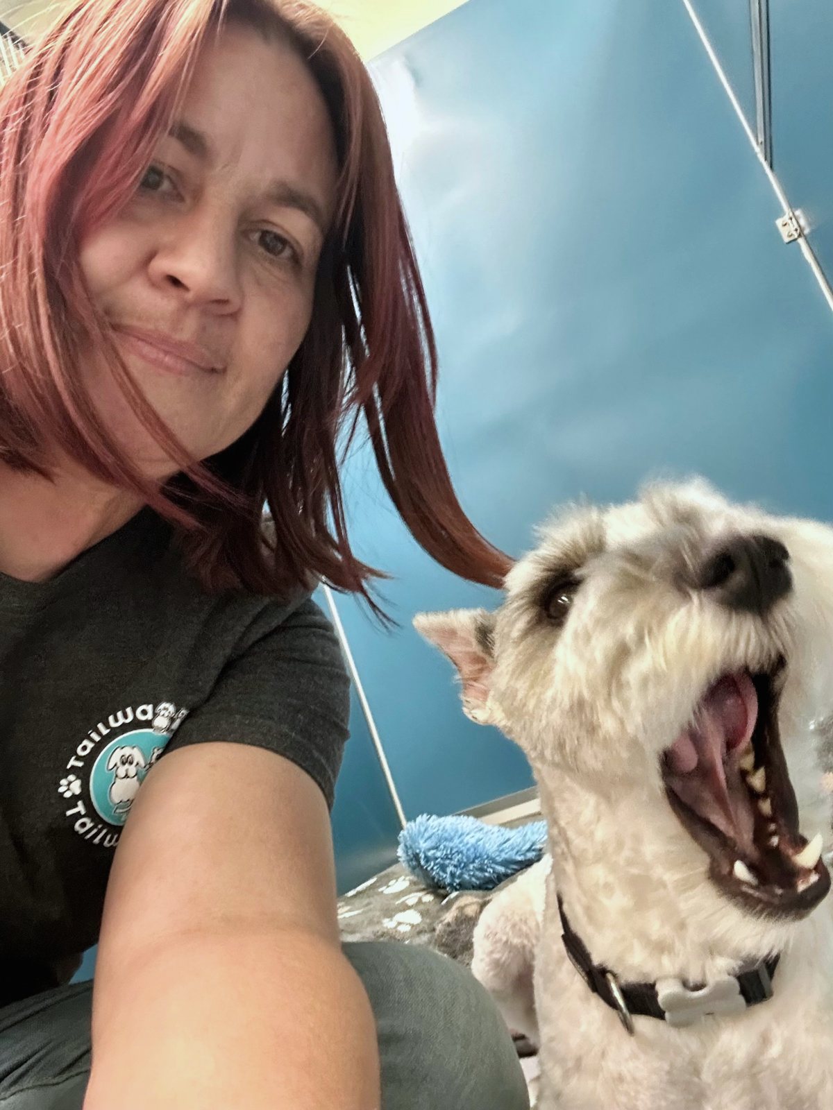 Selfie of a daycare staffer with Joey mid-bark, mouth wide open